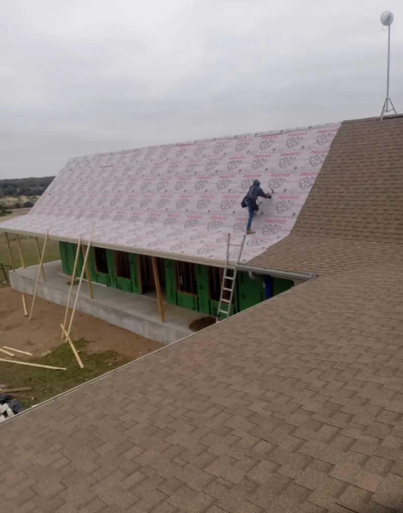 Worker preparing underlayment for a metal roof installation in Bryans Road